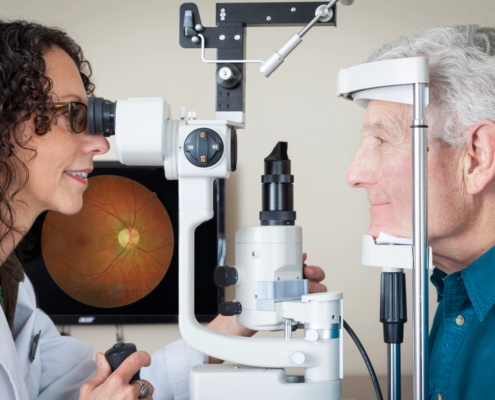 Optometrist giving eye exam to senior patient.