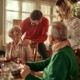 Senior couple and young adult couple hugging over Christmas dinner.