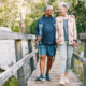 Senior couple hiking over a bridge.