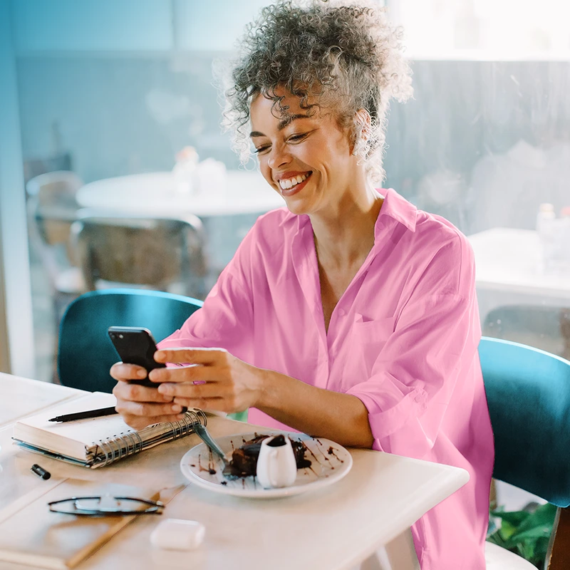 Senior woman smiling while looking at her smartphone.