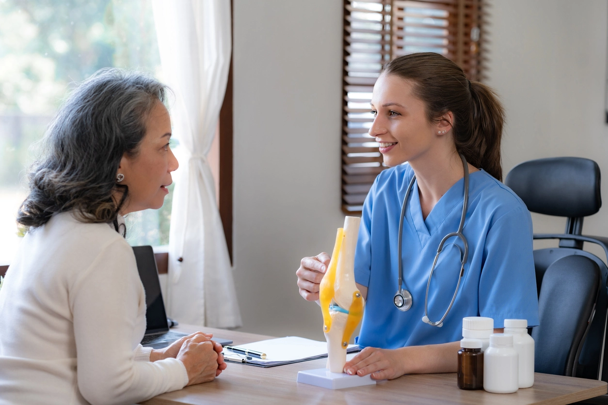 Female doctor is introducing an elderly Asian female patient about bone diseases and treatment method and medicine details.